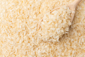 Rice flakes background with spoon.