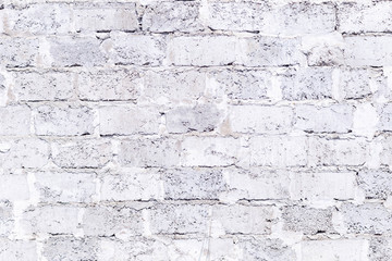plastered brick wall with whitewash,with sloppy brick and crumbling whitewash,taken on a Sunny spring day