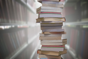 Stacking books with blur bookshelfs background in the library room. Education and knowledge high as a mountain concept.