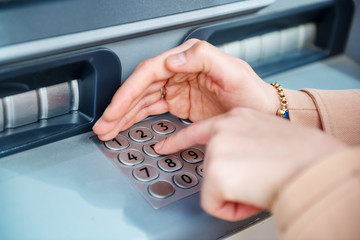 woman hand while using ATM at street