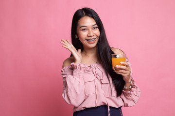 Happy Young Asian woman drink orange juice.