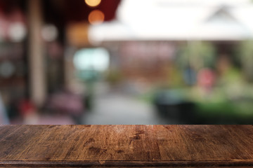 Empty dark wooden table in front of abstract blurred bokeh background of restaurant . can be used for display or montage your products.Mock up for space.