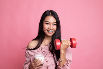 Healthy Asian woman drinking a glass of milk and dumbbell.