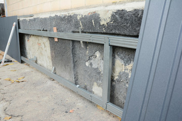 House foundation wall repair,  renovation  with installing metal sheets on metal frame for...