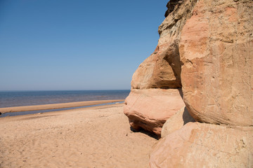Limestone beach at the Baltic Sea, Latvia with beautiful sand pattern and vivid red and orange color - Veczemju Klintis