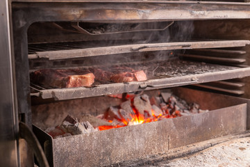 food, craft and delicious concept - cooking steak on a grill