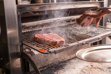food, craft and delicious concept - cooking steak on a grill
