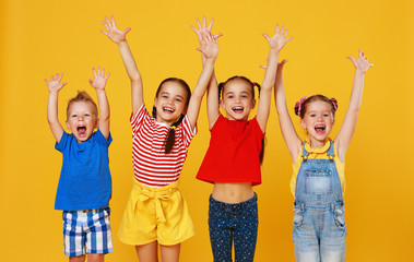 group of cheerful happy children on colored yellow background.