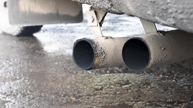 Exhaust fumes , black smoke coming out of the car pipe. Exhaust gases coming out of the exhaust pipe of the car polluting the environment 