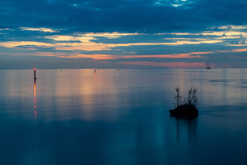 reflections of shore trees in the calm water of a lake