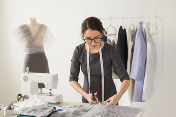 Dressmaker, fashion designer and tailor concept - Young woman designer cuts light fabric