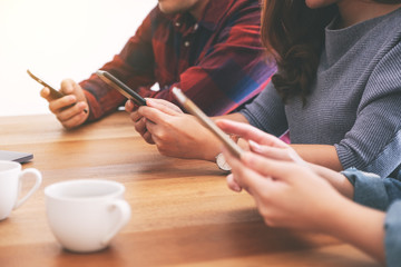 Group of people using and looking at mobile phone and tablet pc while sitting together