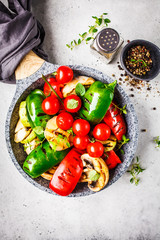 Grilled vegetables (peppers, zucchini, mushrooms and tomatoes in pan, white background.