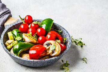 Grilled vegetables (peppers, zucchini, mushrooms and tomatoes in pan, white background.