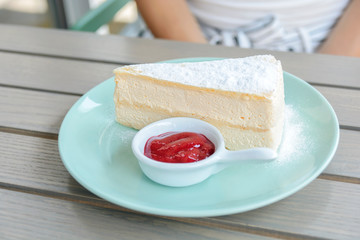 Piece of cream pie of puff vanila pastry in plate on wooden table