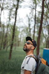 A young guy with a backpack in the cap, traveller in the woods, Hiking, Forest, Journey