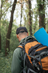 A young guy with a backpack in the cap, traveller in the woods, Hiking, Forest, Journey