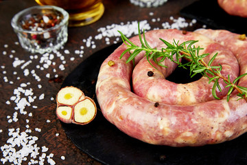 Raw spiral pork sausages with rosemary, salt and peper