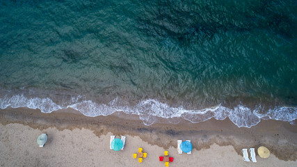 Fototapeta na wymiar Aerial top view on the beach. Umbrellas, sand and ocean. Aerial top view photo of sun beds in popular tropical paradise deep turquoise mediterranean sandy beach in Turkey