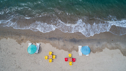 Aerial top view on the beach. Umbrellas, sand and ocean. Aerial top view photo of sun beds in popular tropical paradise deep turquoise mediterranean sandy beach in Turkey