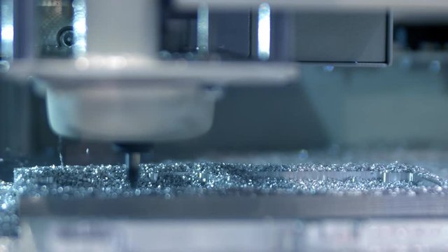 Drilling and metal processing. A small drill grinds the space in the metal. Cut sheet metal at workshop. Modern tool in heavy industry. High precision manufacture of steel parts.