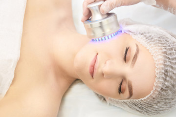 Light infrared therapy. Cosmetology head procedure. Beauty woman face. Cosmetic salon device....