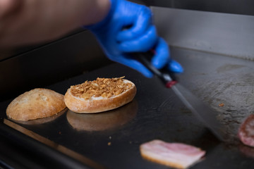 Cocinando hamburguesa en plancha de restaurante