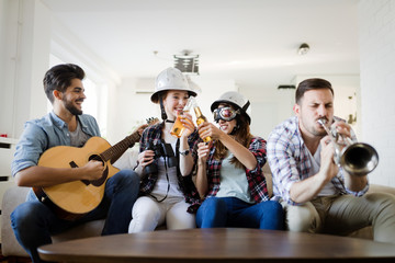 Friends having fun and partying in house and playing music