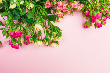 bouquet of small colored roses on a rose  background top view - Image