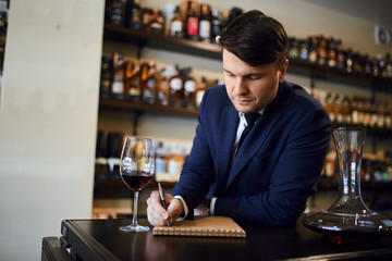 expert writing about the aroma, taste identification, acidity of wine. close up photo