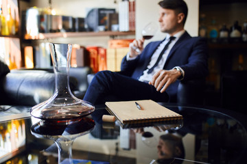 close up photo. focus on the notepad with a pen and decanter . blurred background.