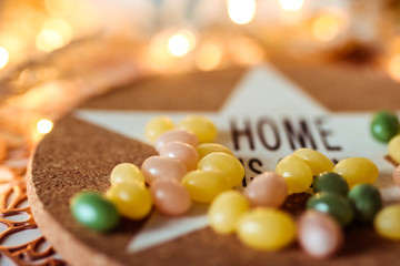 Colorful jellybeans candy and inscription home in the blurred composition.