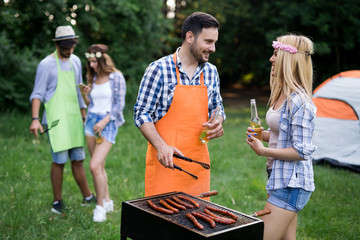 Fototapeta premium Group of happy friends having outdoor barbecue laughing together