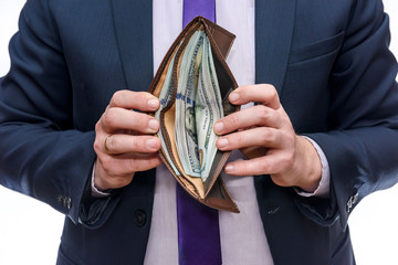 Male hands holding wallet full of dollar banknotes close up