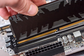Male hand taking out ram memory on motherboard