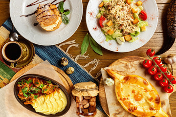 Top view image of traditional georgian lunch with various meals and ingredients at decorated wooden...