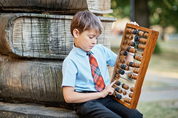 Boy with large abacus. Thoughtful schoolboy using a maths abacus calculation. Farewell Bell. day of knowledge. beginning of the school year