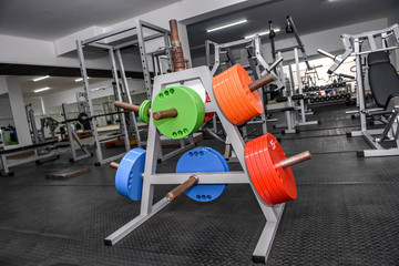 Obraz premium Different colour weights for barbells in gym