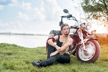 Woman with long hair posing near motorcycle