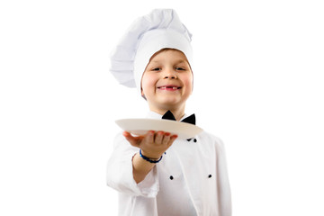 cute funny boy chef in uniform holds a clean empty white plate in his hand