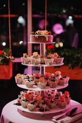 Pink cupcake stand on the white banquet table.