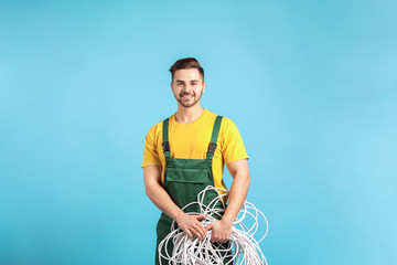 Male electrician on color background