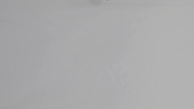 Top view. Female hands deploy a skein of white fabric in white. Open large roll of fabric textile. Tissue or cloth.Clothing designer is working with measurements on a studio table.