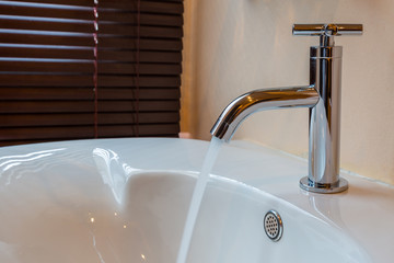 Modern chrome tap faucet with running water