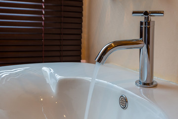 Modern chrome tap faucet with running water