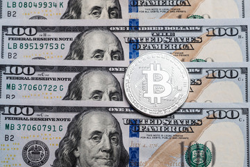 Background with crypto bitcoin and dollars. A symbolic coins of bitcoins on banknotes of one hundred dollars.