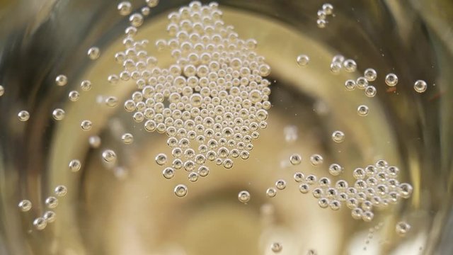 Many small bubbles in a glass. Champagne pouring and foaming over holiday. Christmas celebrating concept