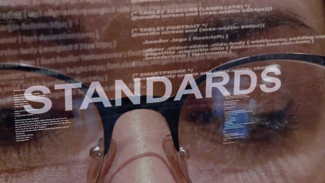 Standards text on the background of female software developer. Eyes of woman with glasses are looking at programming network code space abstract technologies connecting global data network