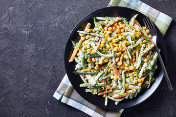 cucumber corn cheese salad on a black plate