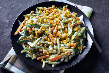cucumber corn cheese salad on a black plate